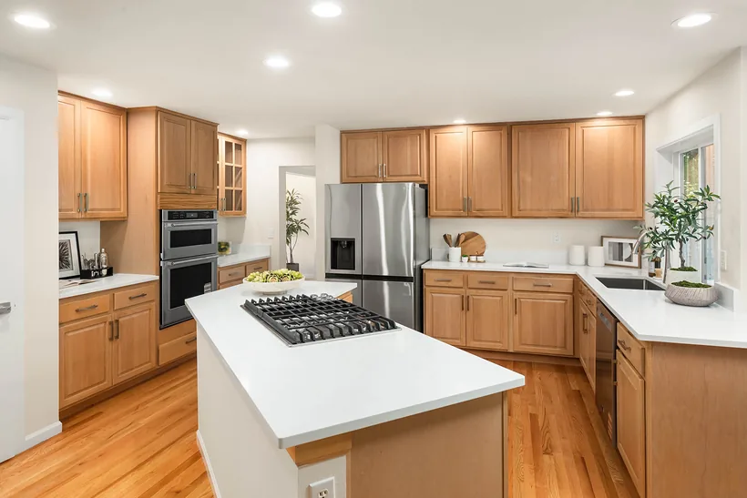 Kitchen with quartz counters, a gas cooktop island, double wall ovens and new stainless appliances